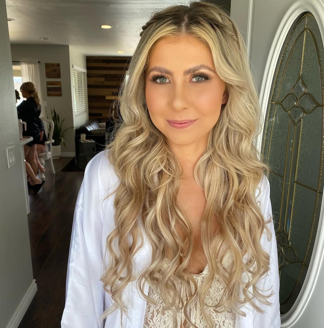 Bride with bronzed makeup and long blonde waves in her robe