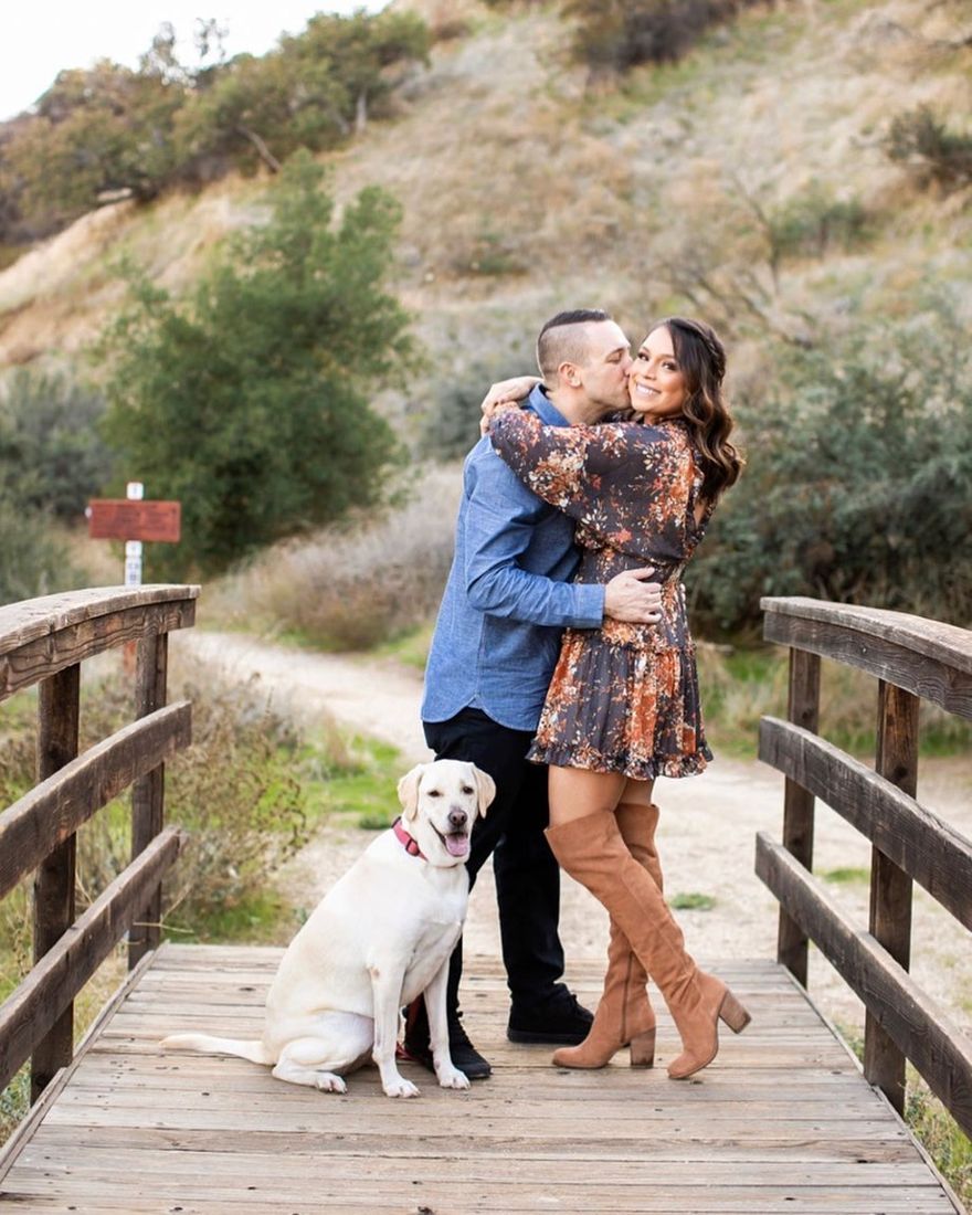 Engagement shoot makeup and soft curls, couple on a wooden bridge with their dog